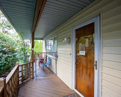 a porch with a wooden door on a house at Rosewood Ranch in Lakewood