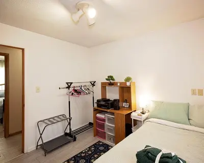 a bedroom with a bed and a desk with a camera at Rosewood Ranch in Lakewood