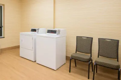 a room with two chairs and a white refrigerator at Fairfield Inn & Suites by Marriott Fort Wayne Southwest in Ellison