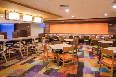 a dining room with tables and chairs at Fairfield Inn & Suites by Marriott Fort Wayne Southwest in Ellison