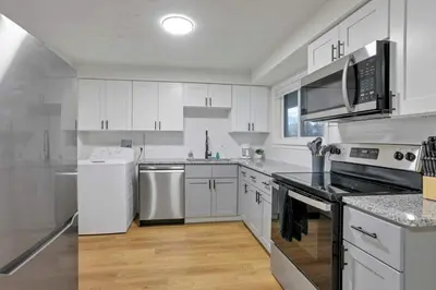 a kitchen with white cabinets and white appliances at The Reynoldsburg Getaway in Reynoldsburg