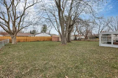 a yard with two trees and a fence at The Reynoldsburg Getaway in Reynoldsburg