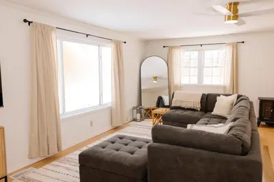a living room with a couch and a large window at The House On Kings Corner in Mansfield