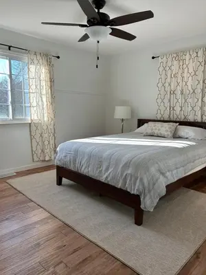 a bedroom with a large bed with a ceiling fan at The House On Kings Corner in Mansfield
