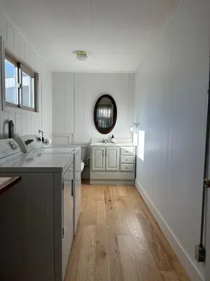 a white kitchen with a sink and a mirror at The House On Kings Corner in Mansfield