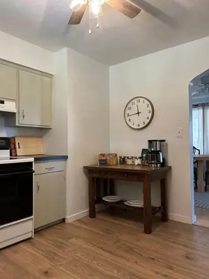a kitchen with a table and a clock on the wall at The House On Kings Corner in Mansfield
