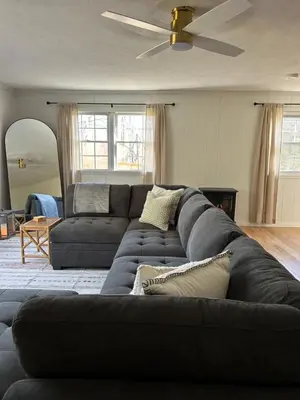 a living room with a couch and a ceiling fan at The House On Kings Corner in Mansfield