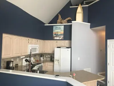a kitchen with blue walls and a white refrigerator at Papa & Gigi's Lake Front Home in Port Clinton