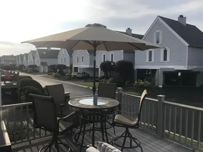 a table and chairs with an umbrella on a balcony at Papa & Gigi's Lake Front Home in Port Clinton