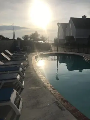 a swimming pool with lounge chairs in front of a house at Papa & Gigi's Lake Front Home in Port Clinton