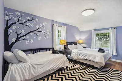 a bedroom with two beds and a tree mural at The Henry House I Pet Friendly Cozy Convenient in Fairview Park