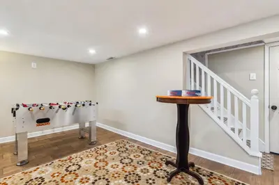 a home office with a table and a stairway at The Henry House I Pet Friendly Cozy Convenient in Fairview Park