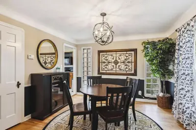 a dining room with a table and chairs and a mirror at The Henry House I Pet Friendly Cozy Convenient in Fairview Park