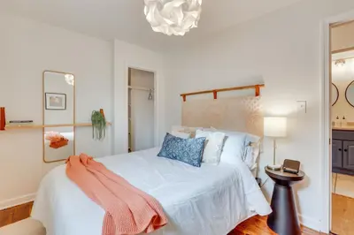 a bedroom with a bed with white sheets and blue pillows at Patio and Lake Views Family-Friendly Canton Retreat in Canton