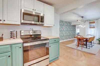 a kitchen with blue cabinets and a table with chairs at Patio and Lake Views Family-Friendly Canton Retreat in Canton