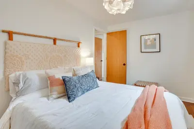 a bedroom with a white bed with pillows and a chandelier at Patio and Lake Views Family-Friendly Canton Retreat in Canton