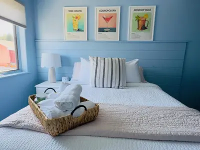 a bedroom with a bed with a basket of towels at The Cocktail Cabin! 2 Miles to Cedar Point in Sandusky