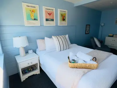 a blue bedroom with two beds and a table with a lamp at The Cocktail Cabin! 2 Miles to Cedar Point in Sandusky