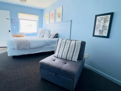 a bedroom with a bed and a chair and a chair at The Cocktail Cabin! 2 Miles to Cedar Point in Sandusky