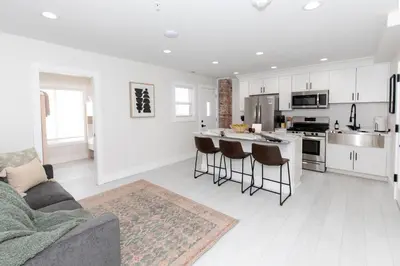 a living room with a couch and a kitchen at Family Duplex Suite in Downtown Sandusky Sleeps 12! in Sandusky