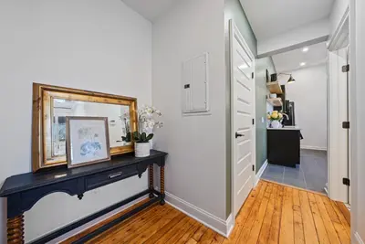 a hallway with a black console table and a mirror at Boutique Style Condo Near Downtown Waterfront in Sandusky