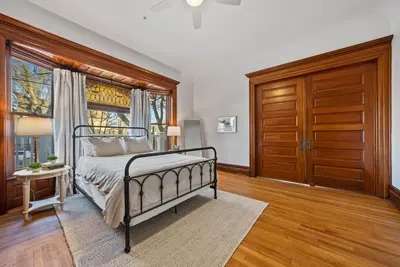 a bedroom with a bed and a wooden door at Boutique Style Condo Near Downtown Waterfront in Sandusky