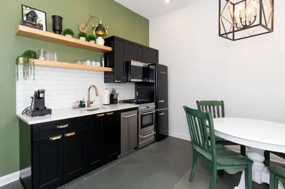 a kitchen with black cabinets and a table with chairs at Boutique Style Condo Near Downtown Waterfront in Sandusky