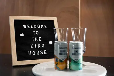 a welcome to the king house sign and two glasses at Tiny Home for a King in Dayton
