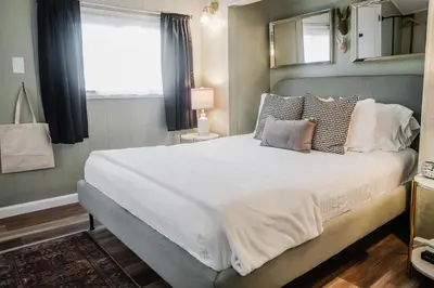a bedroom with a large bed with white sheets and pillows at Tiny Home for a King in Dayton