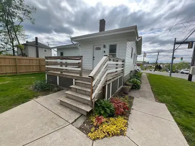 a small house with a porch with a wooden staircase at Cozy at Anderson Towne Center in Cincinnati