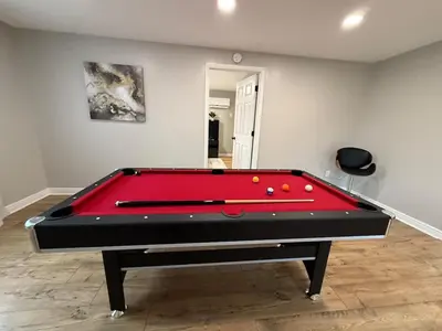 a pool table in a room with a red pool at Just like home w Pool & Pool table in Milford