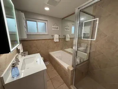 a bathroom with a tub and a sink and a shower at Just like home w Pool & Pool table in Milford