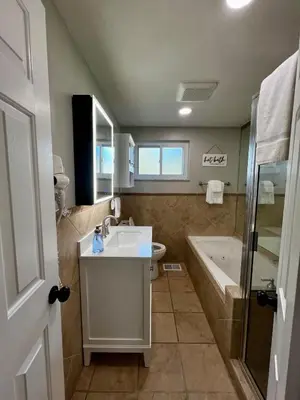 a bathroom with a sink and a tub and a toilet at Just like home w Pool & Pool table in Milford