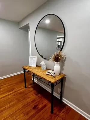 a table with a mirror on a wall at Just like home w Pool & Pool table in Milford