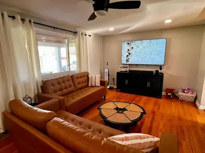a living room with a couch and a flat screen tv at Just like home w Pool & Pool table in Milford