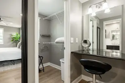 a bathroom with a mirror and a desk and a bed at Amazing Pool & Walk to the Park in Cincinnati