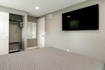 a bedroom with a bed and a flat screen tv at Amazing Pool & Walk to the Park in Cincinnati