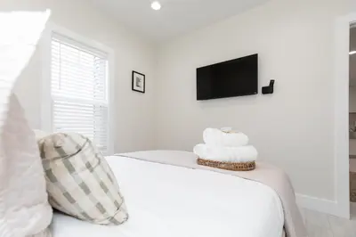 a white bedroom with a bed with towels on it at Adjoining Condominium Units Sleeps 12 in Downtown Sandusky! in Sandusky