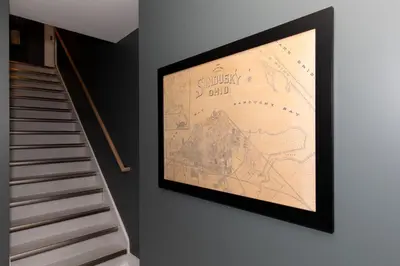 a picture of a map on the wall next to a staircase at Adjoining Condominium Units Sleeps 12 in Downtown Sandusky! in Sandusky