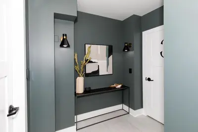 a hallway with green walls and a table and a mirror at Adjoining Condominium Units Sleeps 12 in Downtown Sandusky! in Sandusky