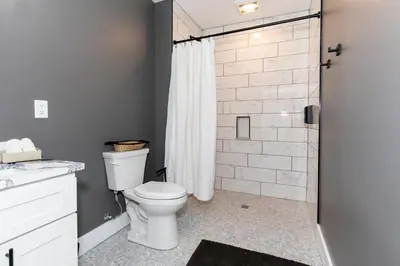 a bathroom with a toilet and a shower at Adjoining Condominium Units Sleeps 12 in Downtown Sandusky! in Sandusky