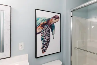 a picture of a turtle on the wall in a bathroom at At the Beach - Old Homestead Beach House in Huron