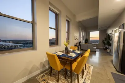 a dining room with a table and yellow chairs at King Bed, Reds, Bengals, Free Parking, Downtown Cincy in Cincinnati