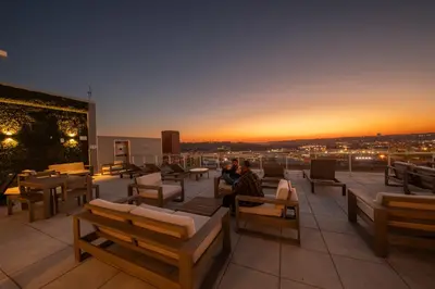 a man sitting on the roof of a building with a sunset at King Bed, Reds, Bengals, Free Parking, Downtown Cincy in Cincinnati