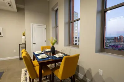 a dining room with a table and yellow chairs at King Bed, Reds, Bengals, Free Parking, Downtown Cincy in Cincinnati