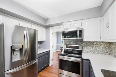a kitchen with a stainless steel refrigerator and white cabinets at Peaceful Dove in Tylersville