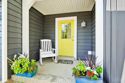 a yellow door on a house with a bench at Peaceful Dove in Tylersville