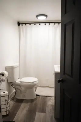 a bathroom with a toilet and a shower curtain at Buckeye Lake Getaway in Thornville