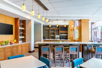 a bar in a restaurant with tables and chairs at Hyatt Place at The Hollywood Casino Pittsburgh South in Washington
