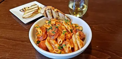 a bowl of pasta and bread and a glass of wine at Hyatt Place at The Hollywood Casino Pittsburgh South in Washington